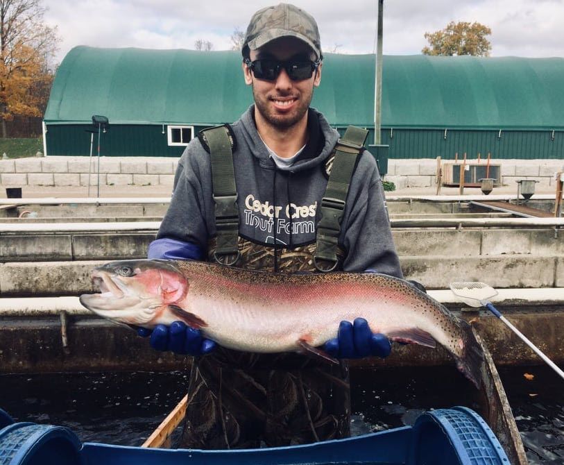 man fish farmer posing with rainbow trout