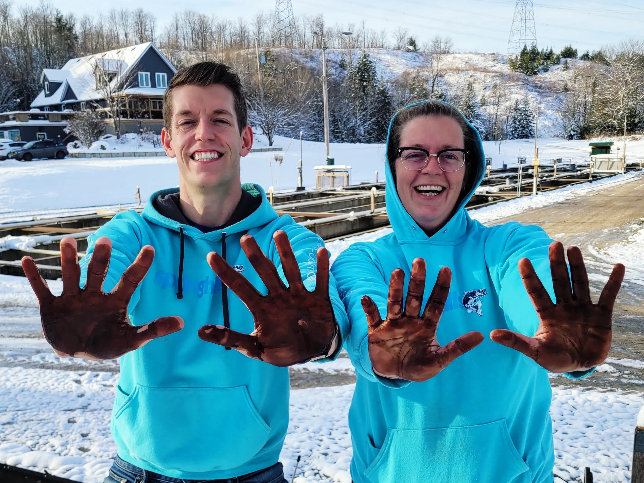 fish farmers posing with peat moss carbon on hands fish feed